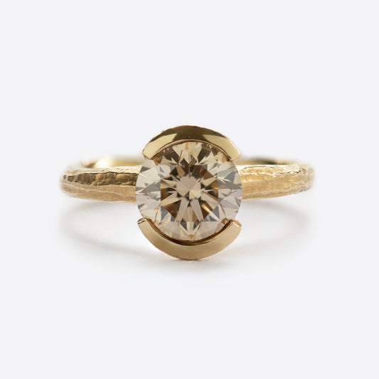 Yellow metal ring with round gem