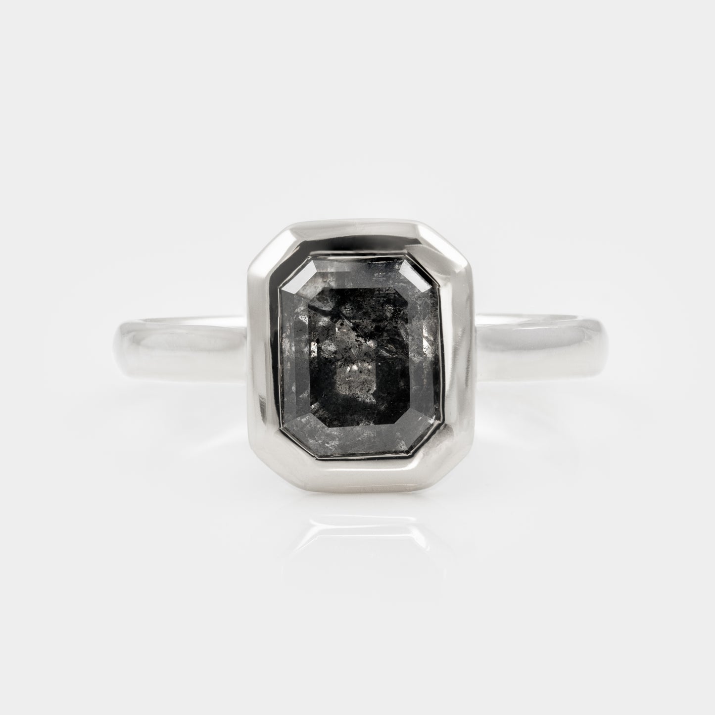 White gold ring with a large, dark gemstone on a white background