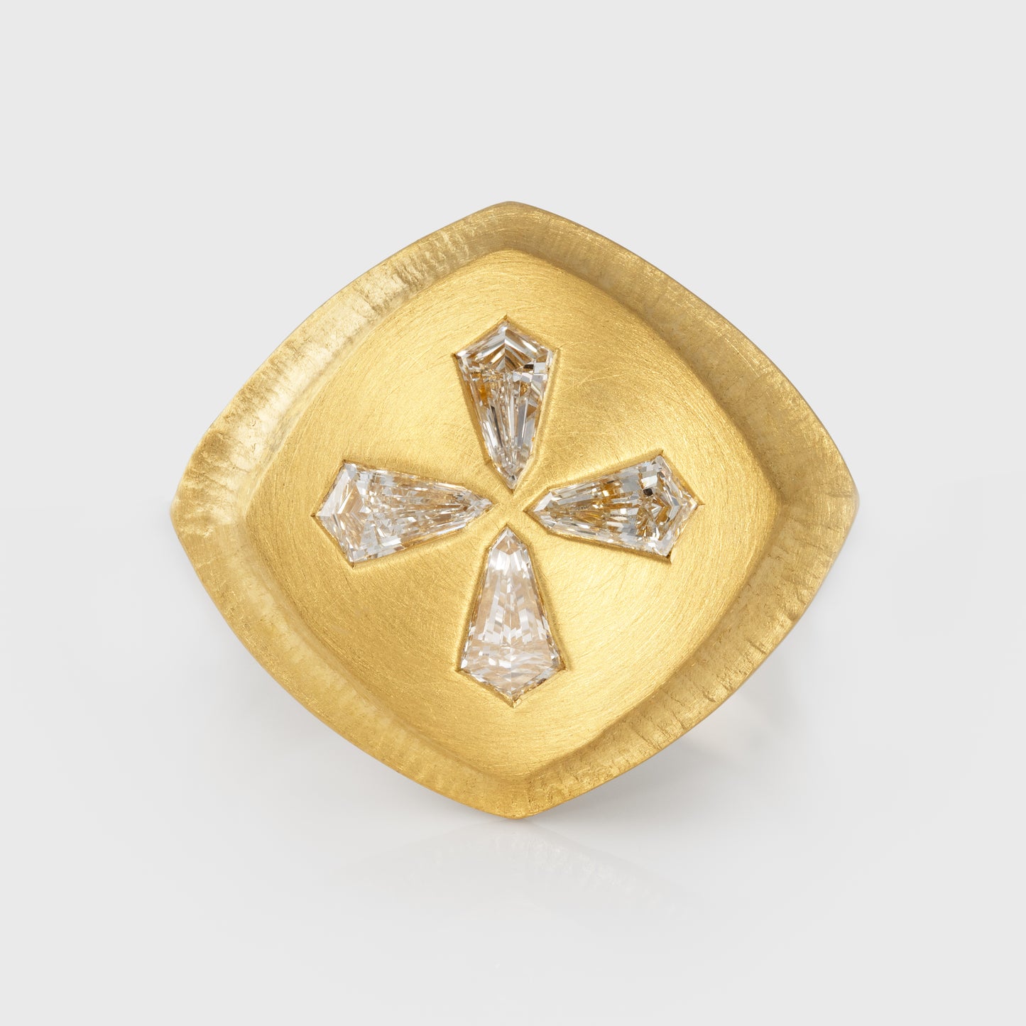 Gold ring with four diamonds on a light gray background