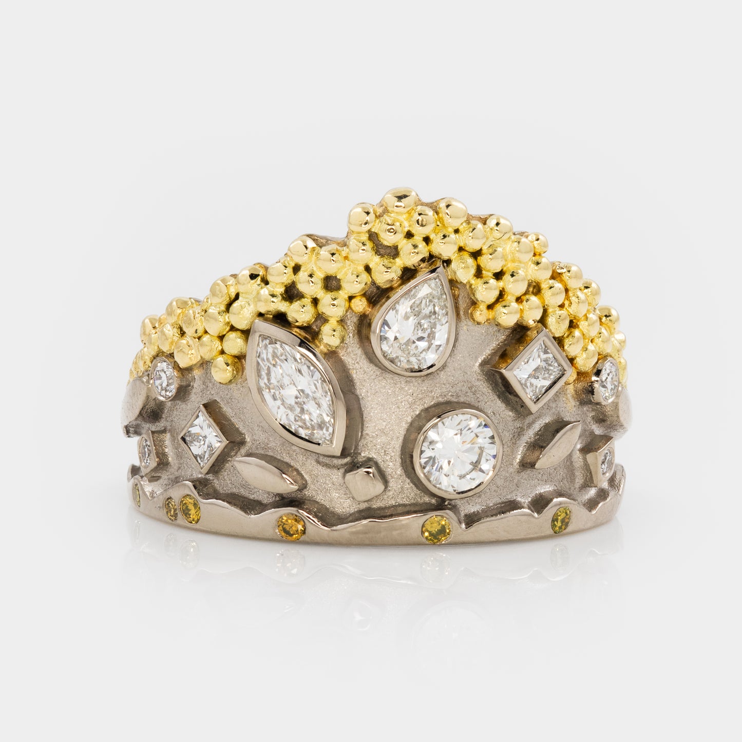 White gold ring with gold granulation and mixed diamond shapes on a white background