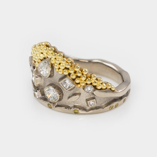 White gold ring with gold granulation and mixed diamond shapes on a white background, three-fourths view