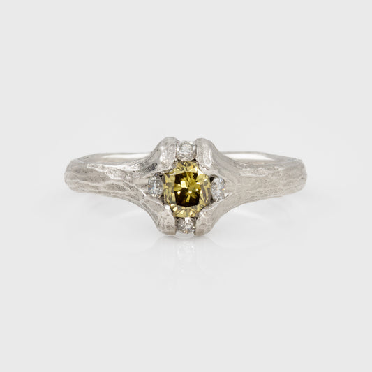 Platinum ring with yellow-brown diamond and redwood bark texture on a white background