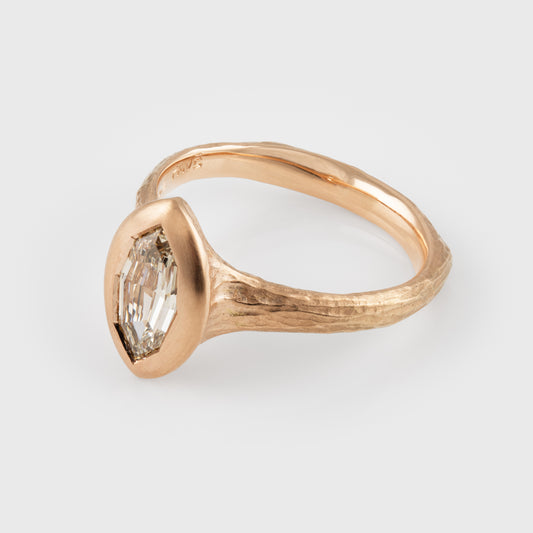 Rose gold ring with a diamond on a light gray background