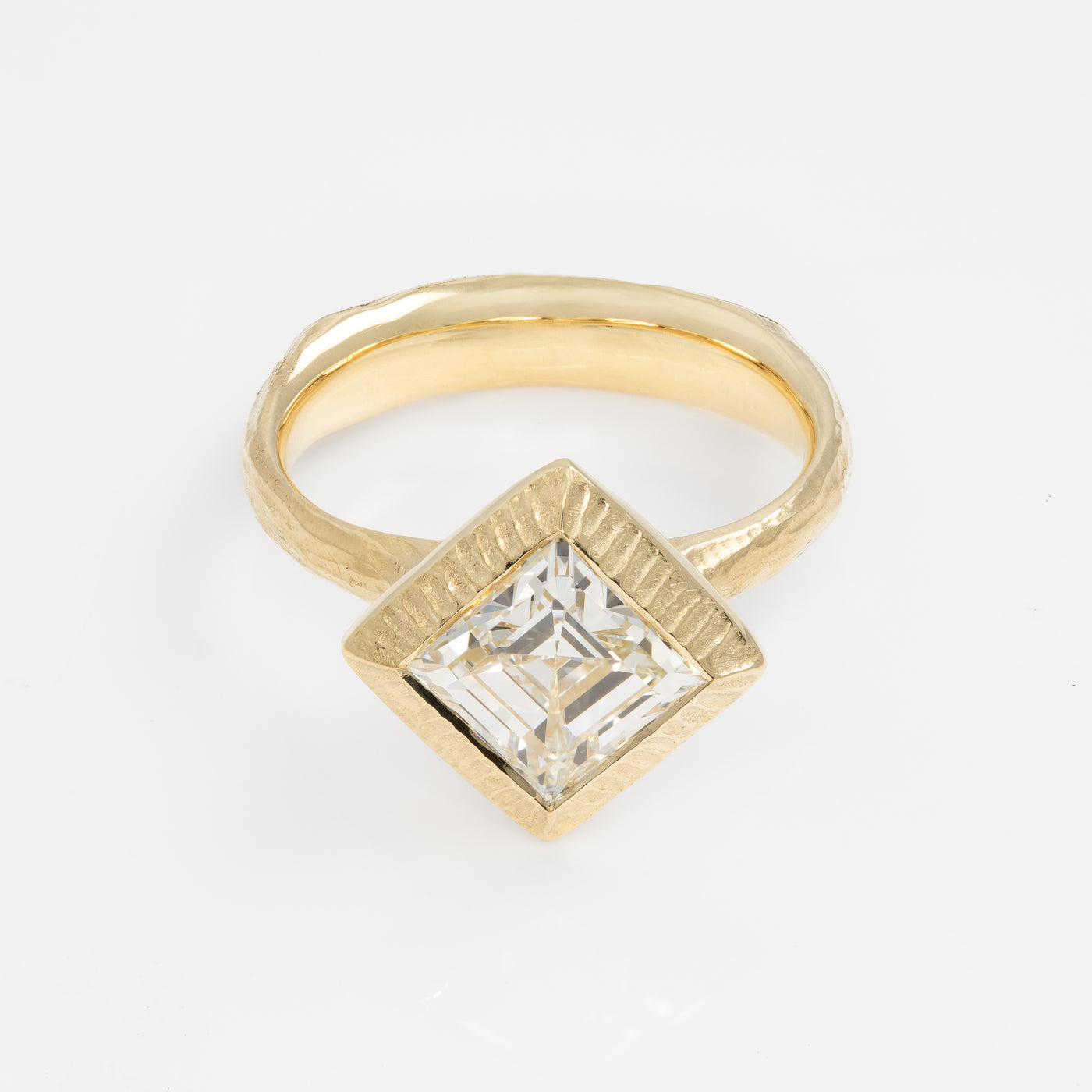 Gold ring with a square-cut diamond on a white background