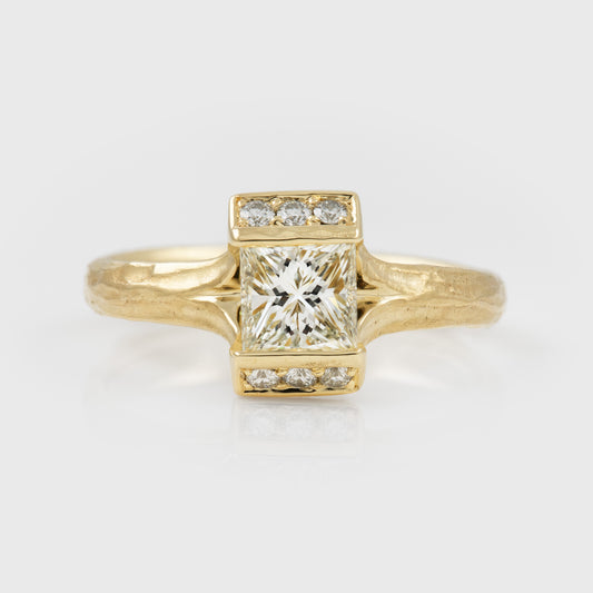 Gold ring with a large diamond and smaller diamonds on a light gray background