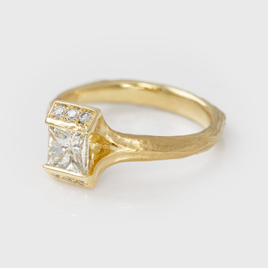 Gold ring with diamonds on a light gray background