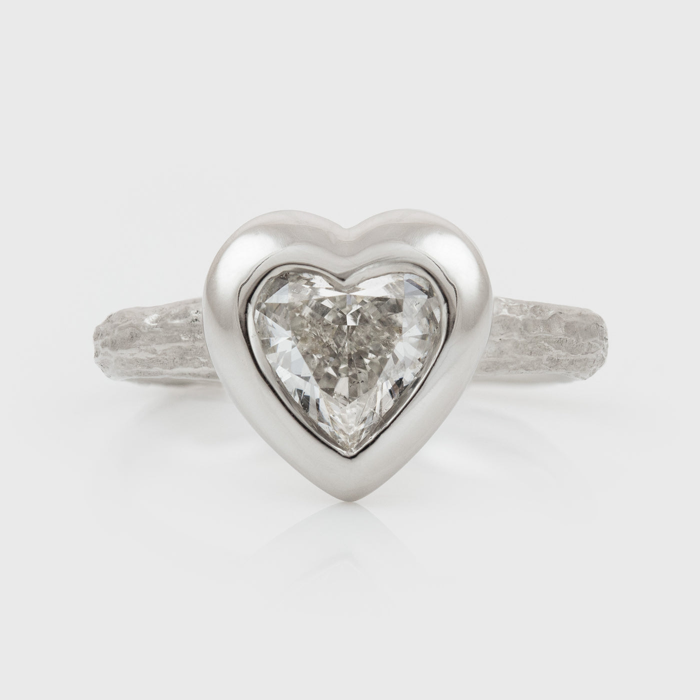 Platinum heart shaped diamond ring on a white background