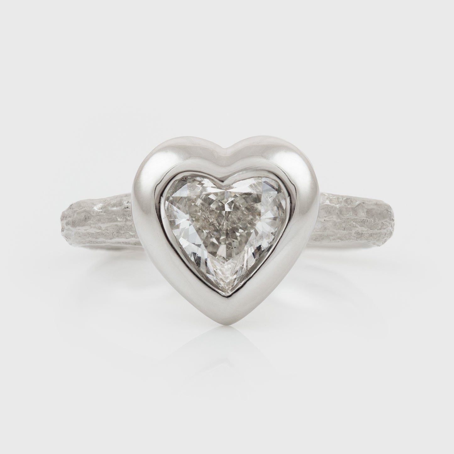 Platinum heart shaped diamond ring on a white background
