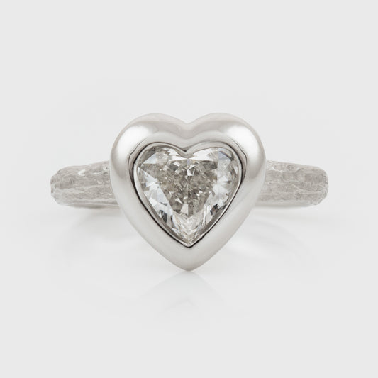 Platinum heart shaped diamond ring on a white background