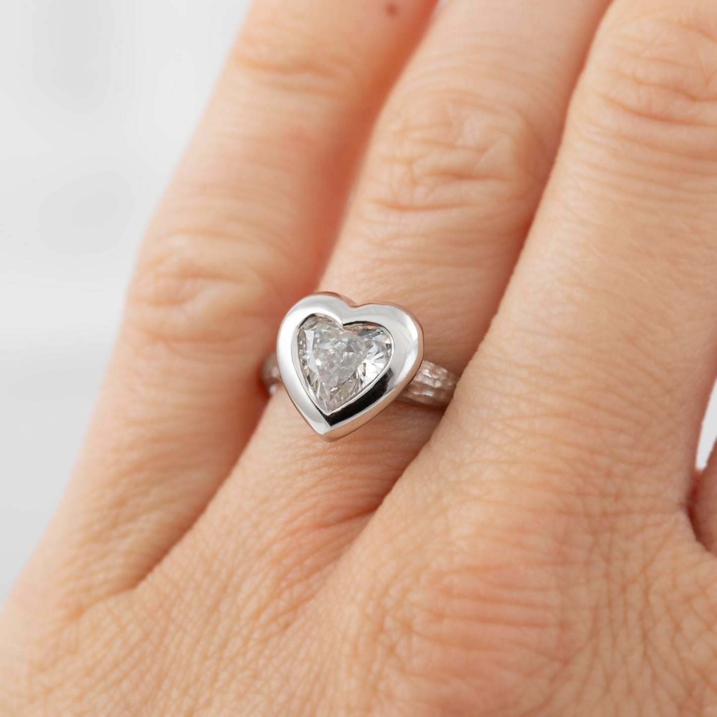 Platinum heart shaped diamond ring on a hand