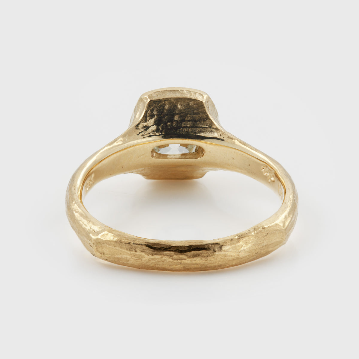 Back shot of Yellow gold ring featuring a hybrid old-cut diamond center stone set in a high-polish bezel with a textured band, photographed on a white background.