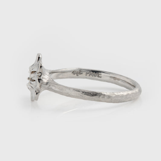 Side view of platinum ring featuring a  yellow diamond center stone surrounded by brushed petal details and a textured band, photographed on a white. Band reads PAVE.