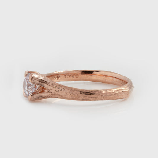 Side view of rose gold ring featuring a light pink diamond center stone and a textured band, photographed on a white background. Side band reads PAVE