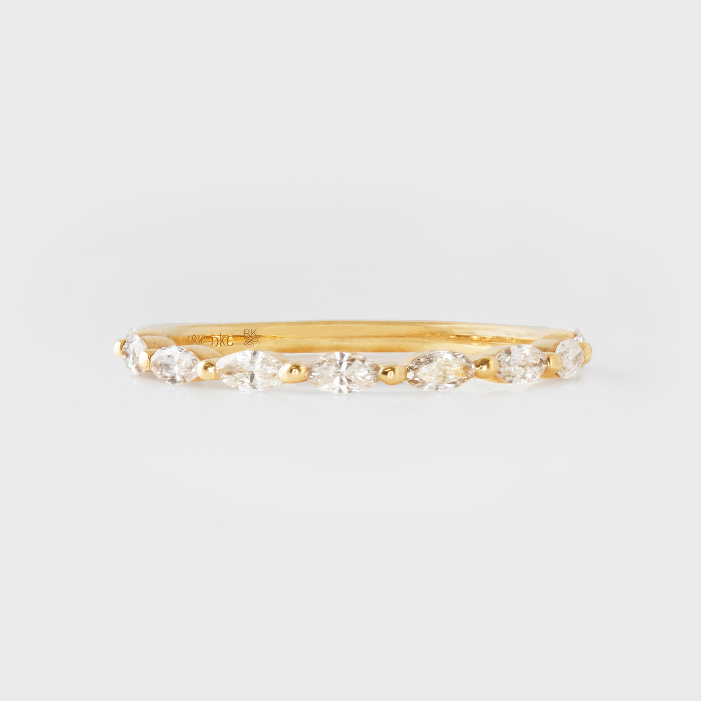 Gold ring with diamonds on a light gray background