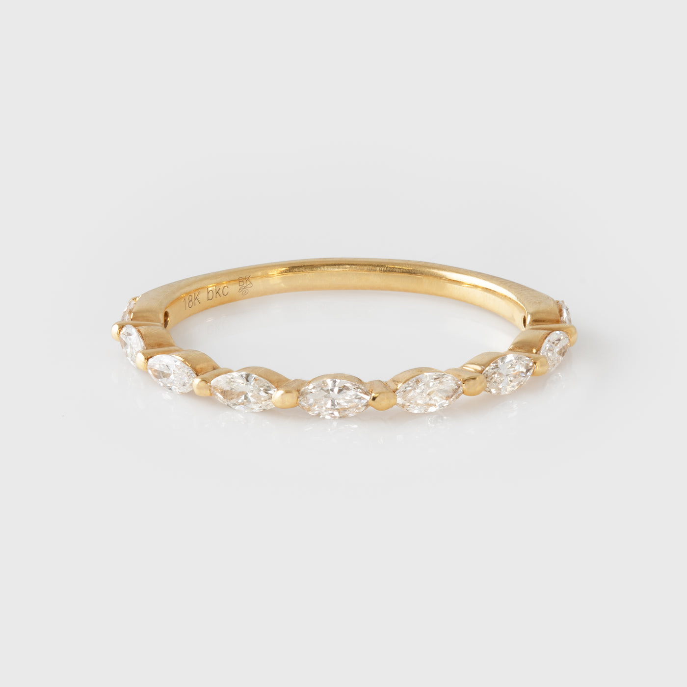 Gold ring with diamonds on a light gray background