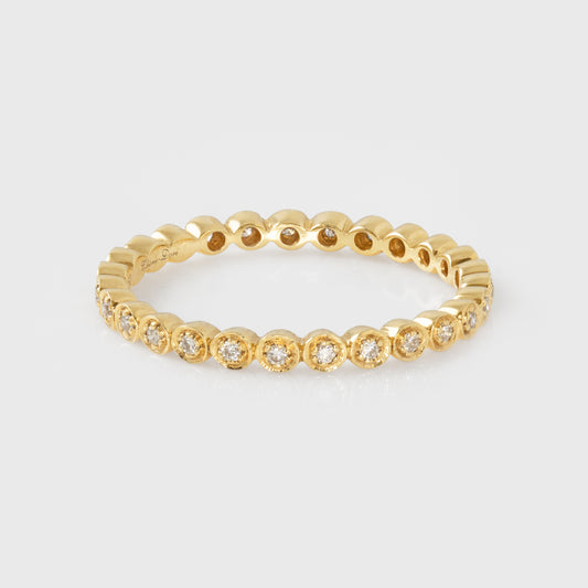 Gold ring with diamonds on a light gray background