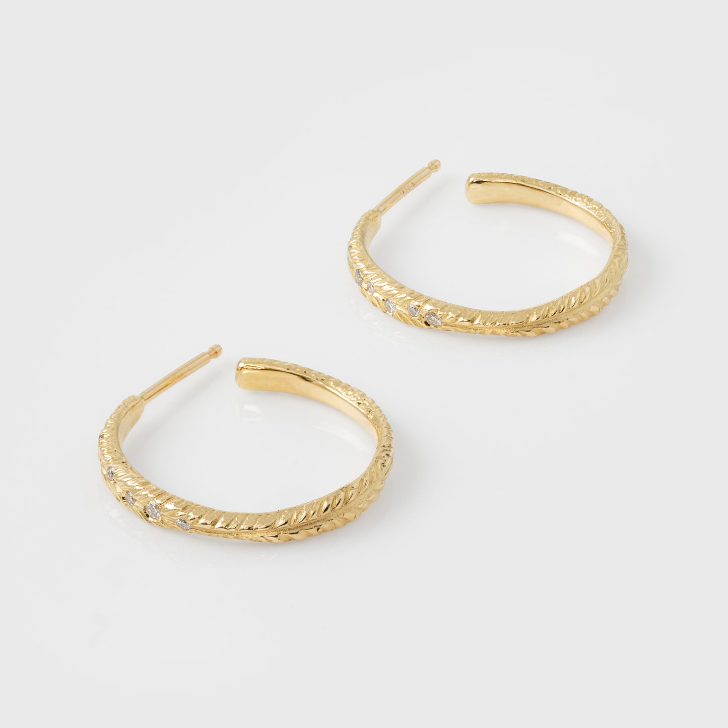 Gold hoop earrings on a light gray background