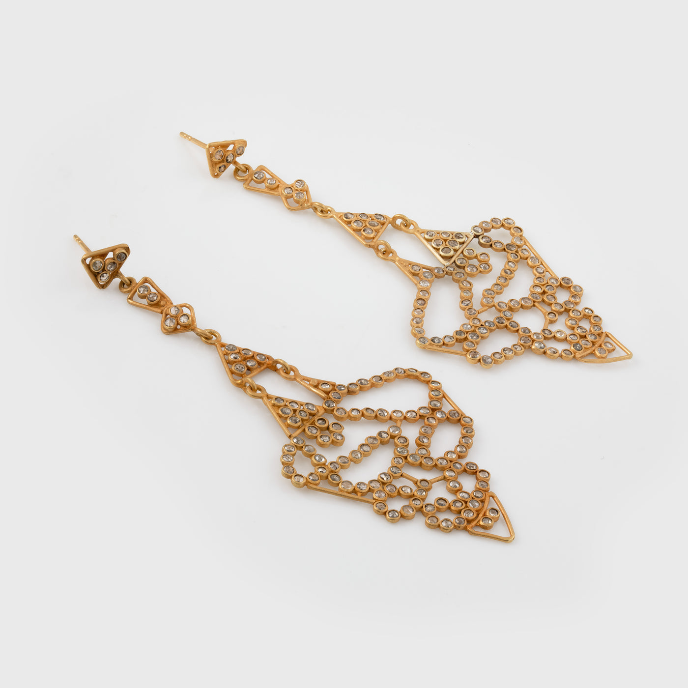 Gold earrings with intricate designs on a white background