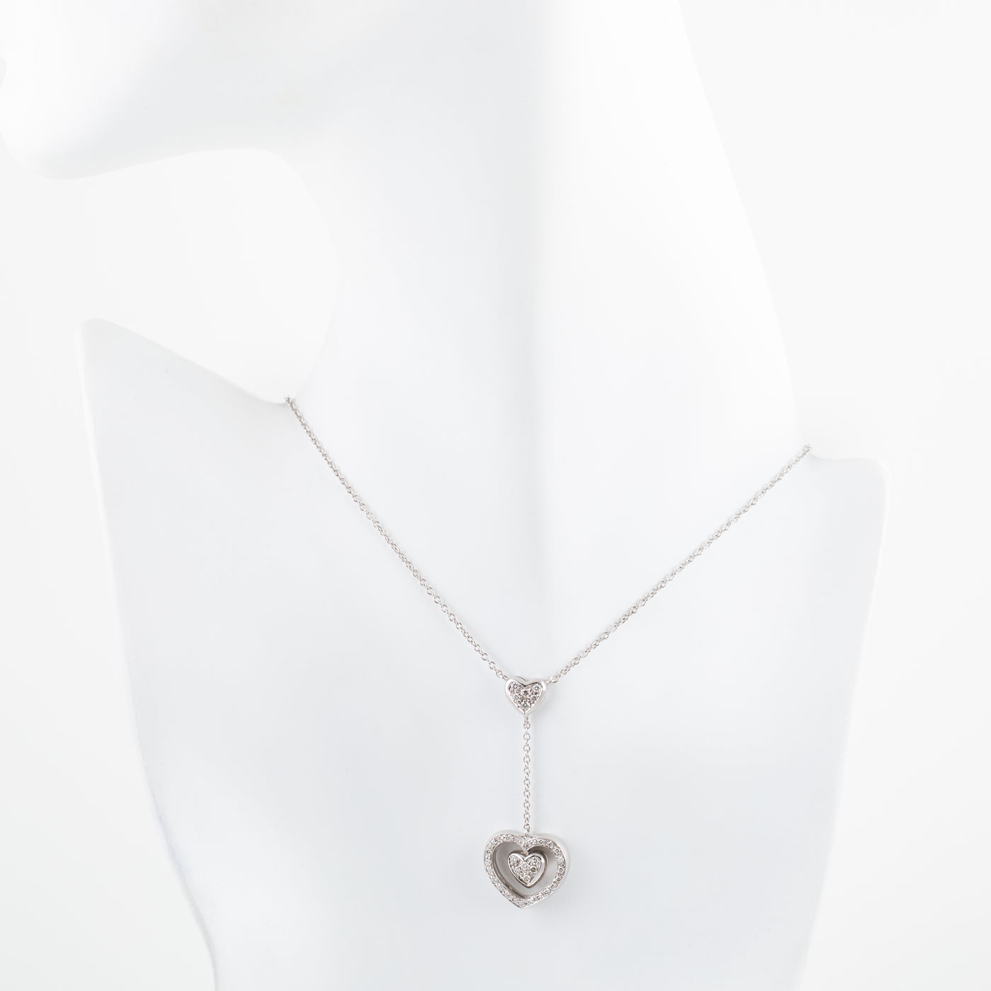 Silver necklace with a heart-shaped pendant on a white background