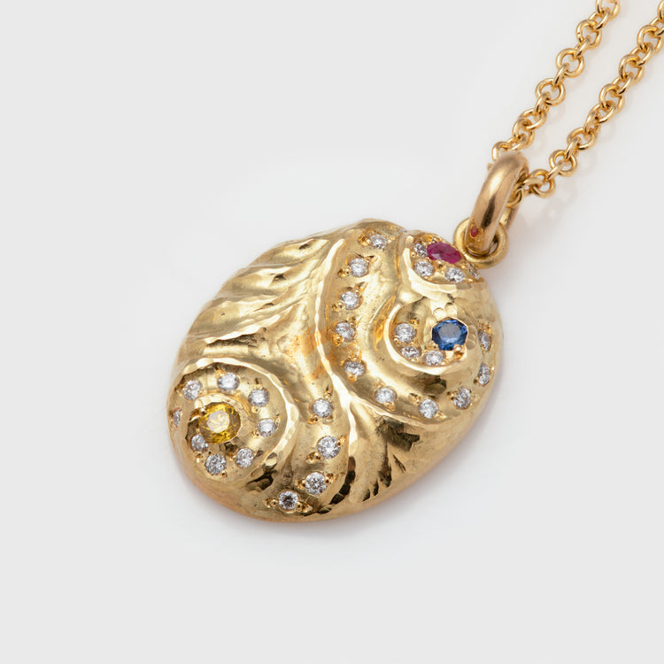 Close-up of a "Song" pendant in 18k yellow gold with yellow diamonds, round diamonds VS DG, a round blue sapphire, and a round ruby on a cable chain.