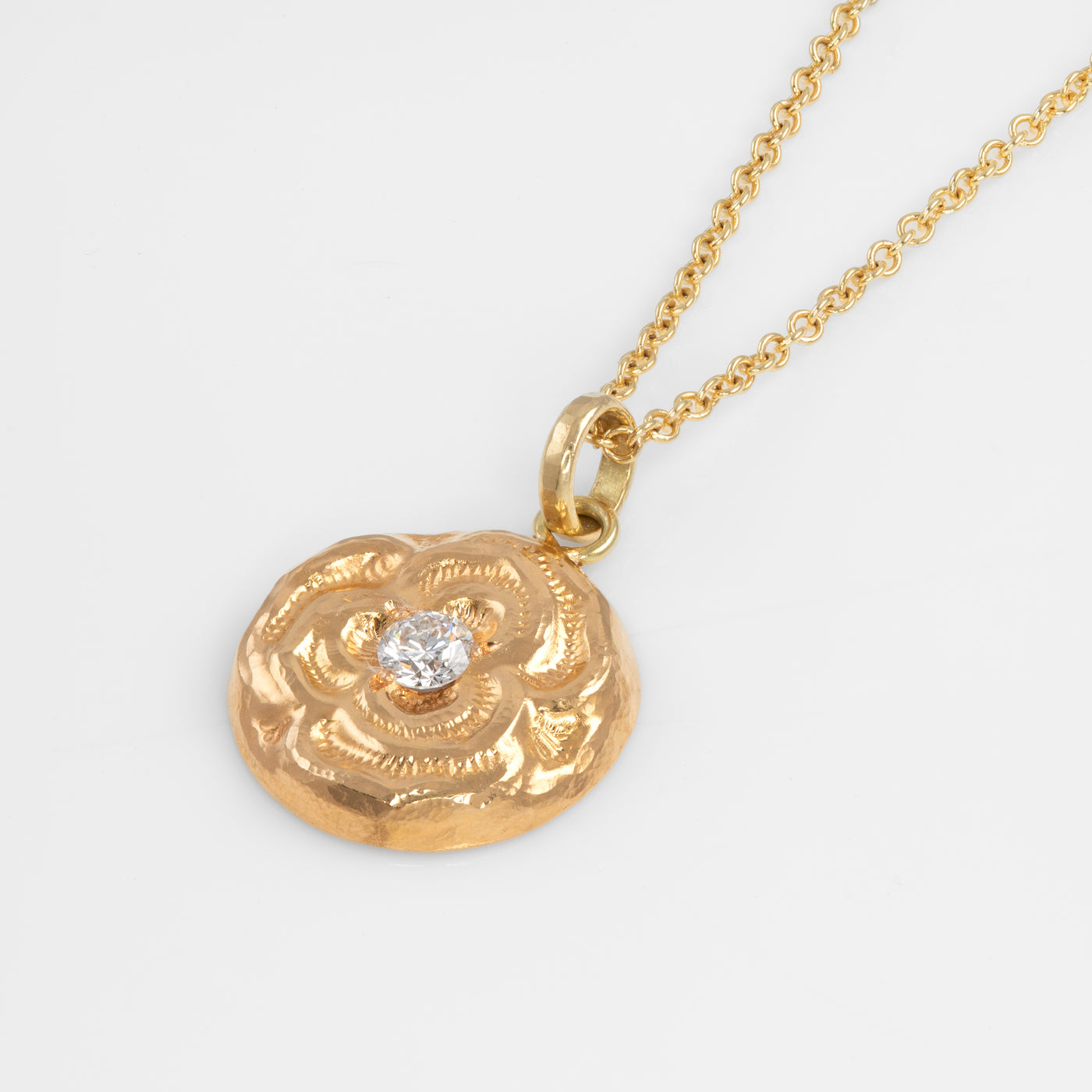 Gold necklace with a decorative pendant on a white background