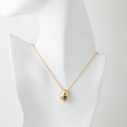 Gold necklace with a triangle-shaped pendant on a mannequin bust.