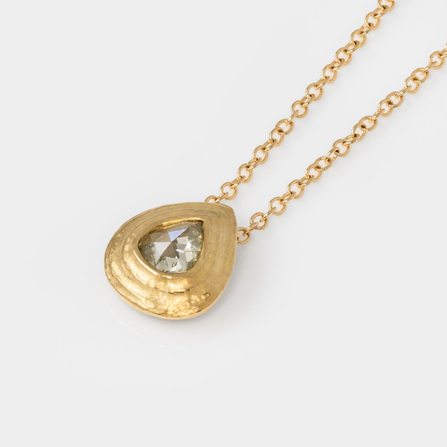 Gold necklace with a teardrop-shaped pendant on a white background