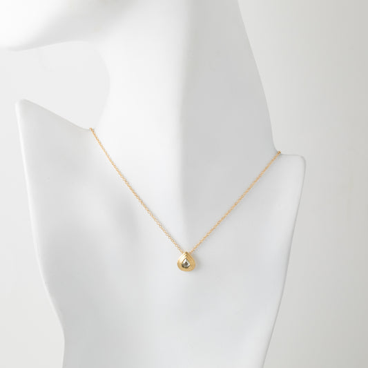 Gold necklace with a small pendant on a mannequin bust against a white background