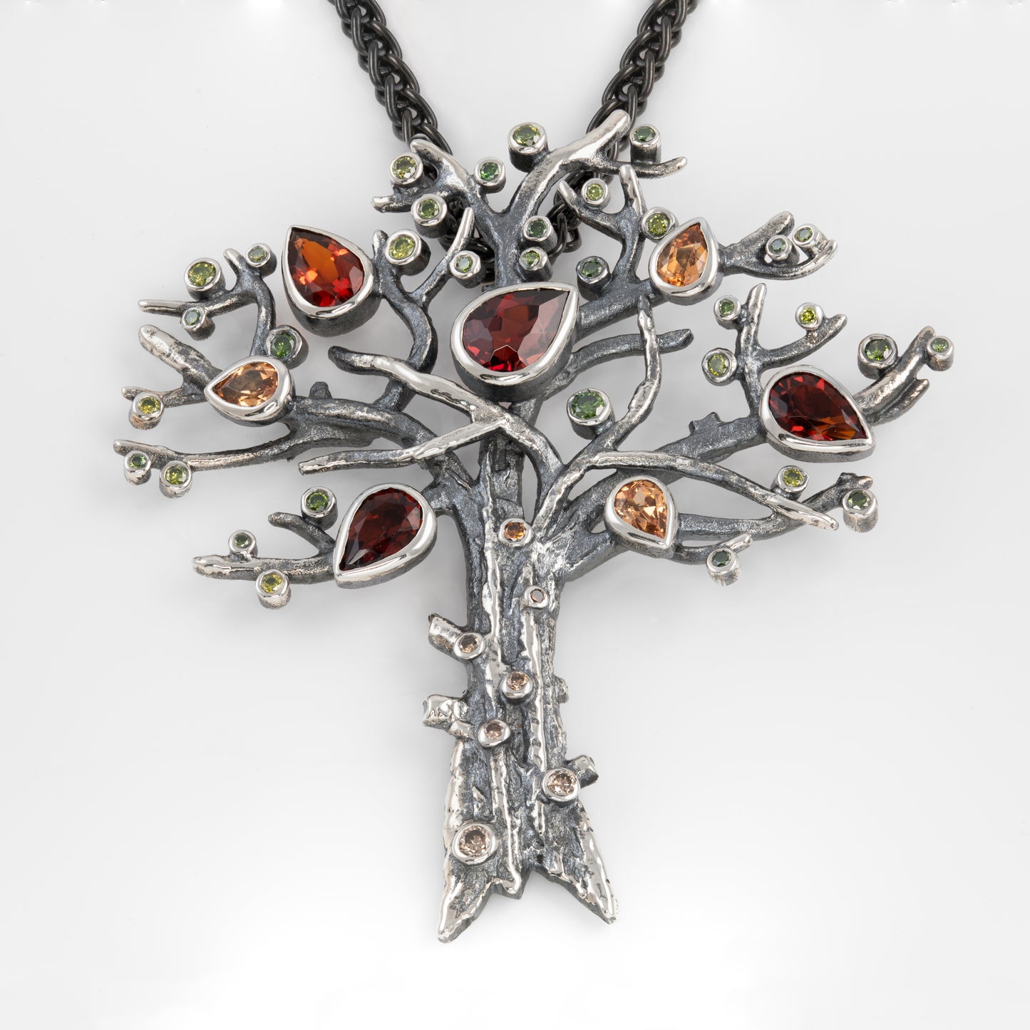 Tree-shaped pendant with gemstones on a white background