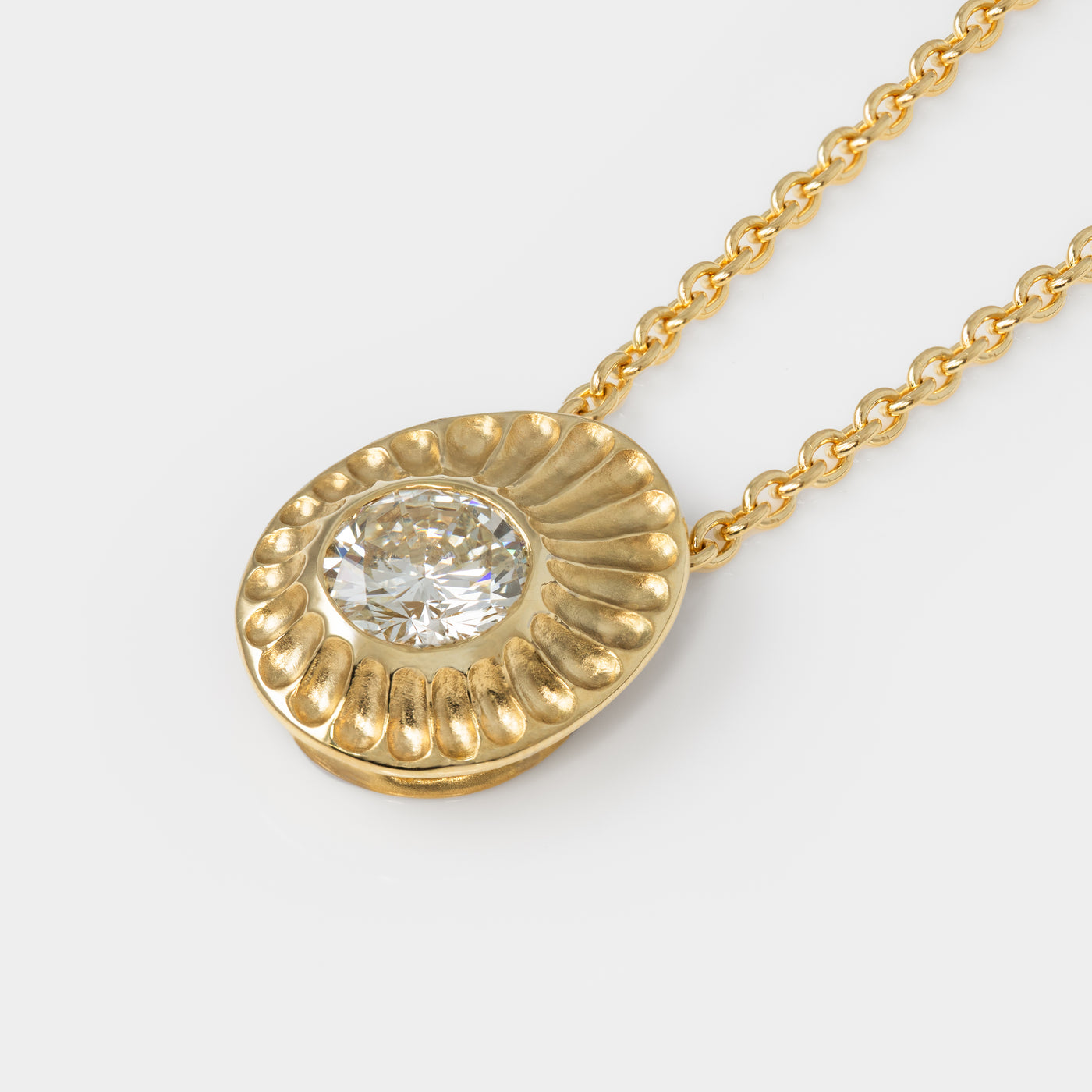 Gold necklace with a diamond pendant on a white background