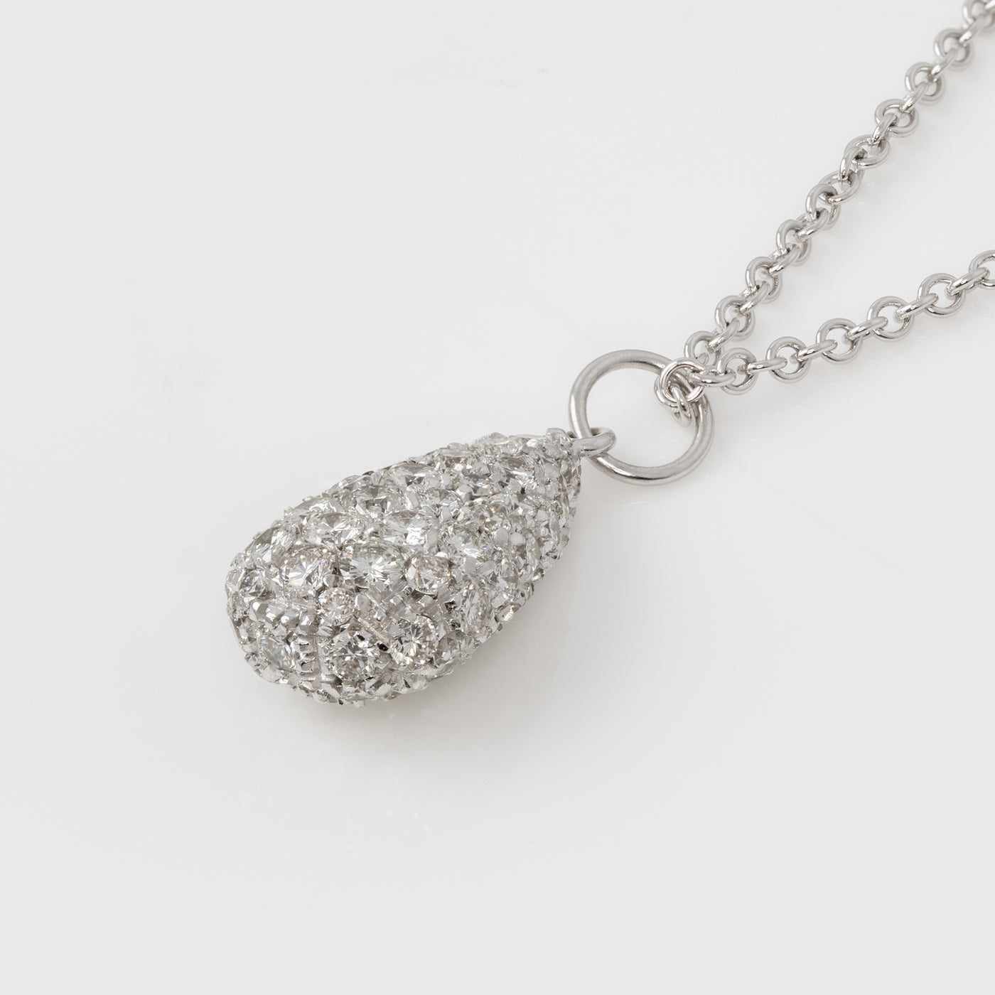 Silver teardrop pendant necklace with diamonds on a white background