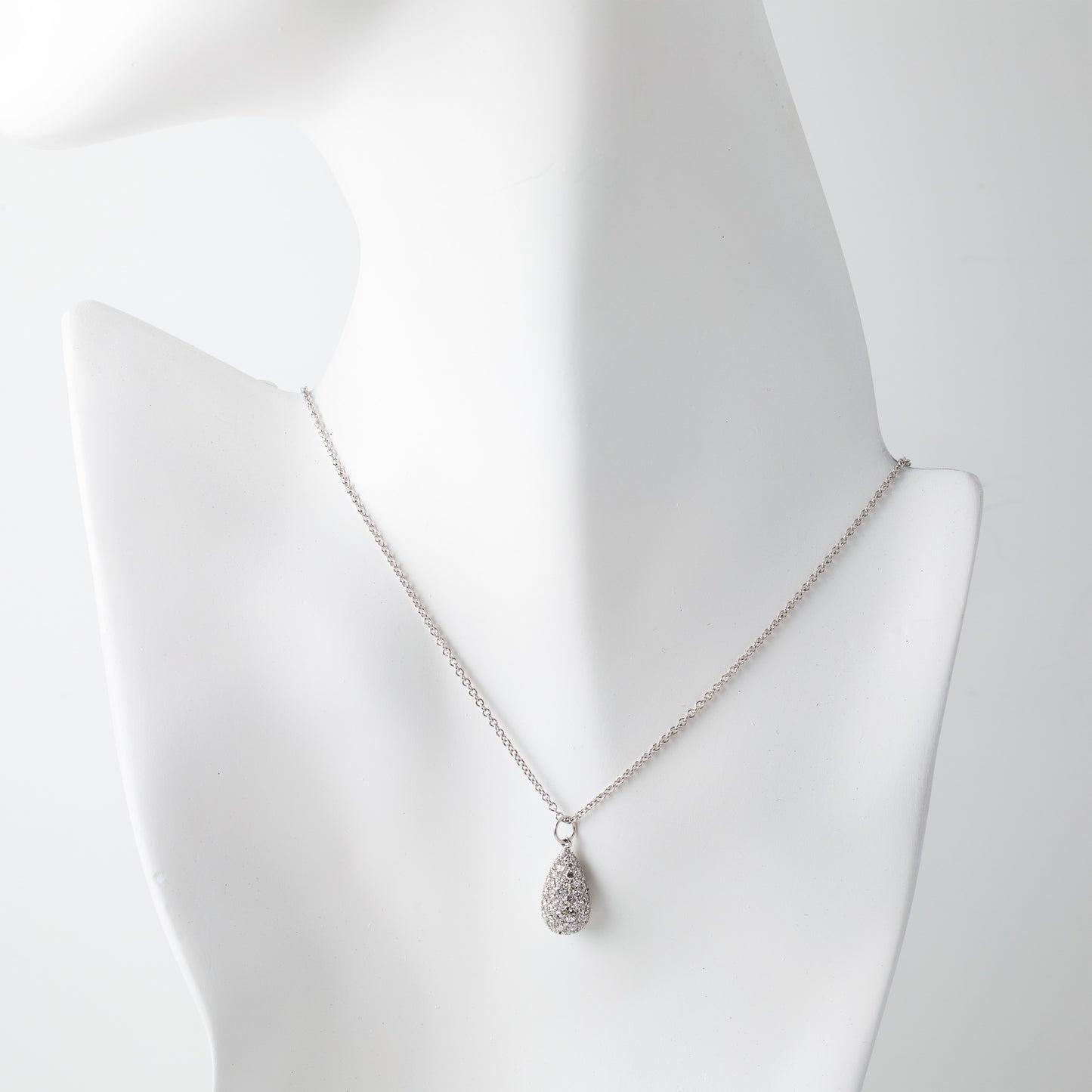 Silver teardrop pendant necklace with diamonds on a white mannequin