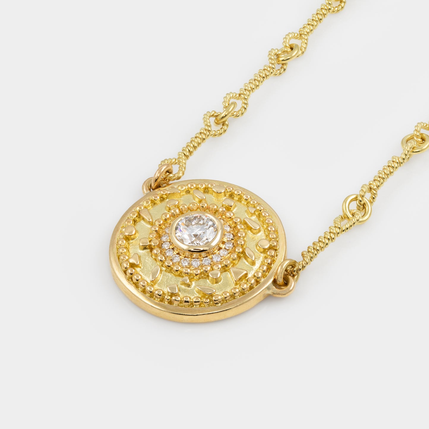 Gold necklace with a decorative pendant on a white background