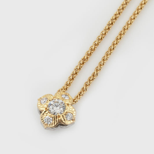 Two-tone flower pendant featuring diamonds, suspended from a yellow gold chain, photographed on a white background.