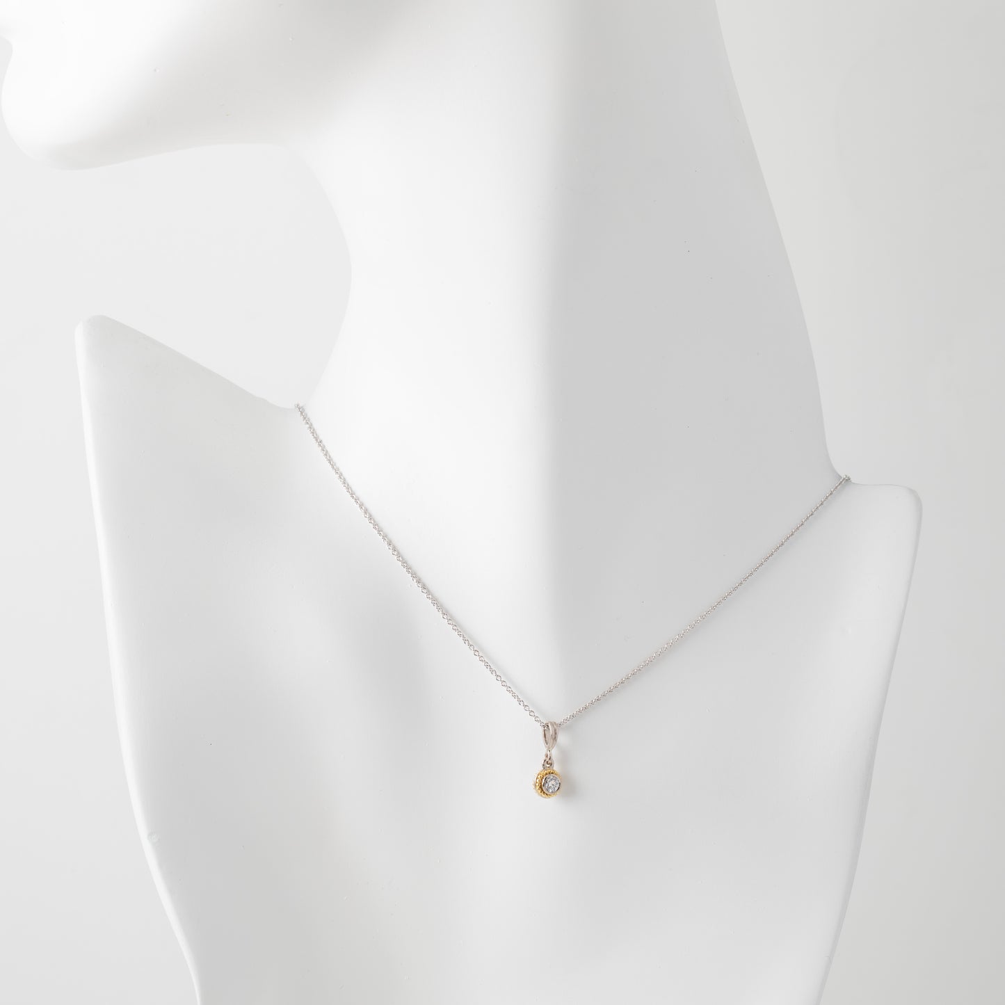 Gold necklace on a mannequin with a white background