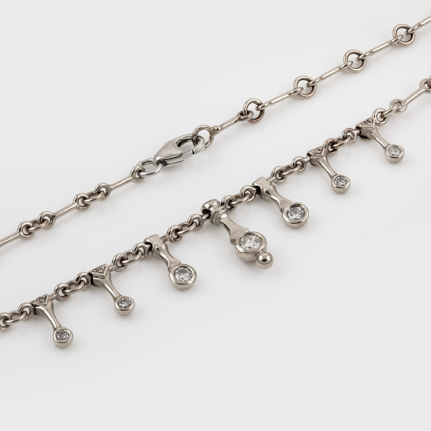 Silver toned necklace on a white background