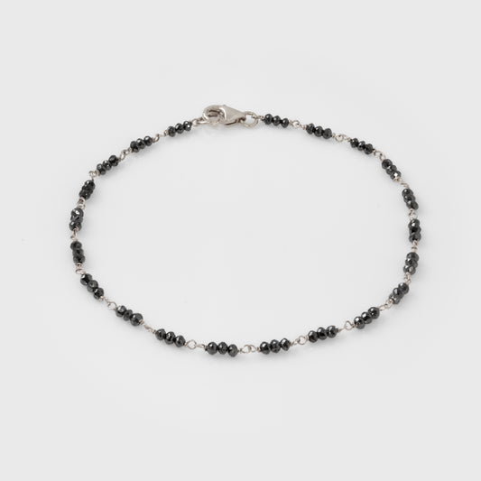 Bracelet with black beads and white gold clasp on a white background