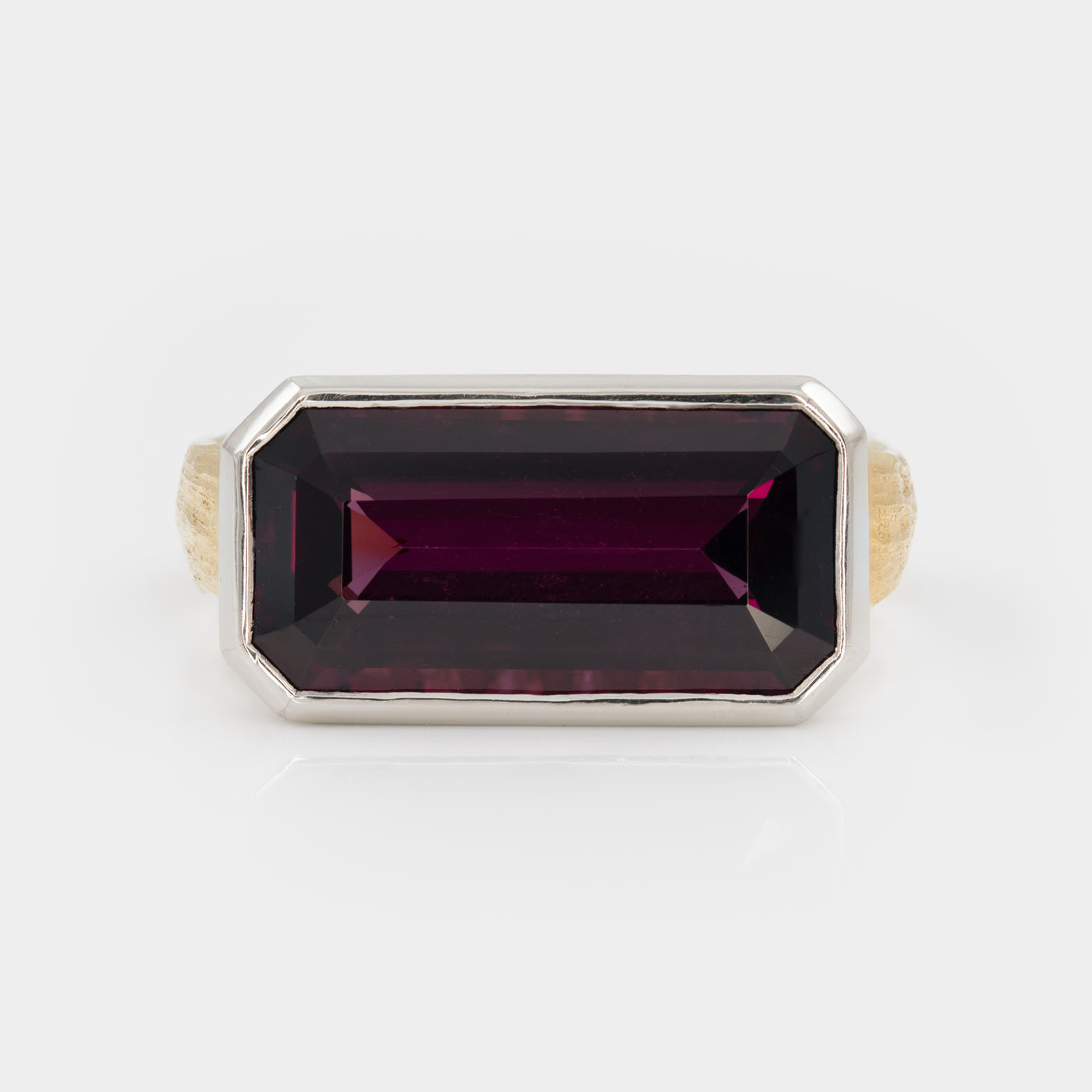 Ring with a rectangular purple gemstone on a white background