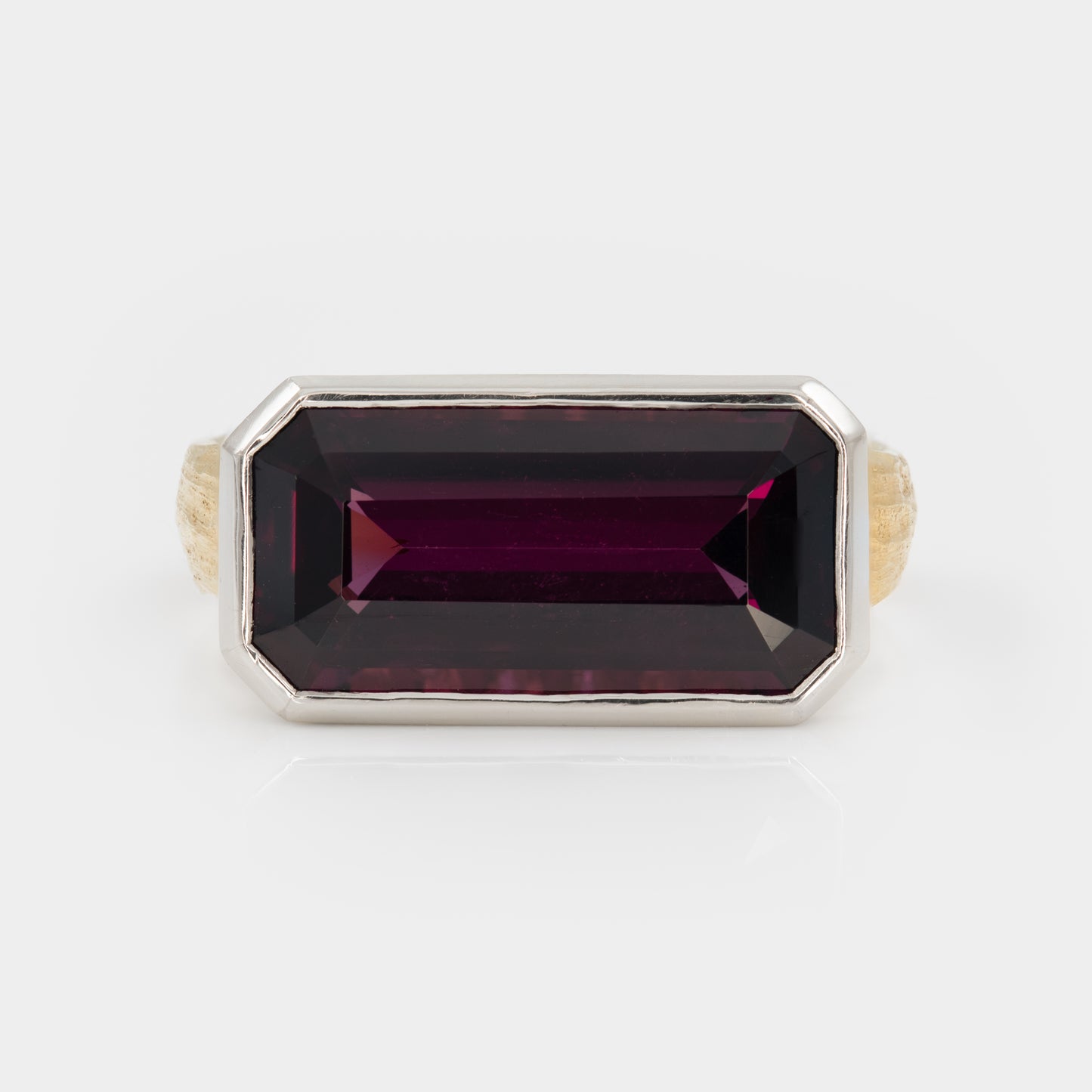 Ring with a rectangular purple gemstone on a white background