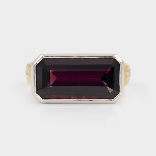 Ring with a rectangular purple gemstone on a white background