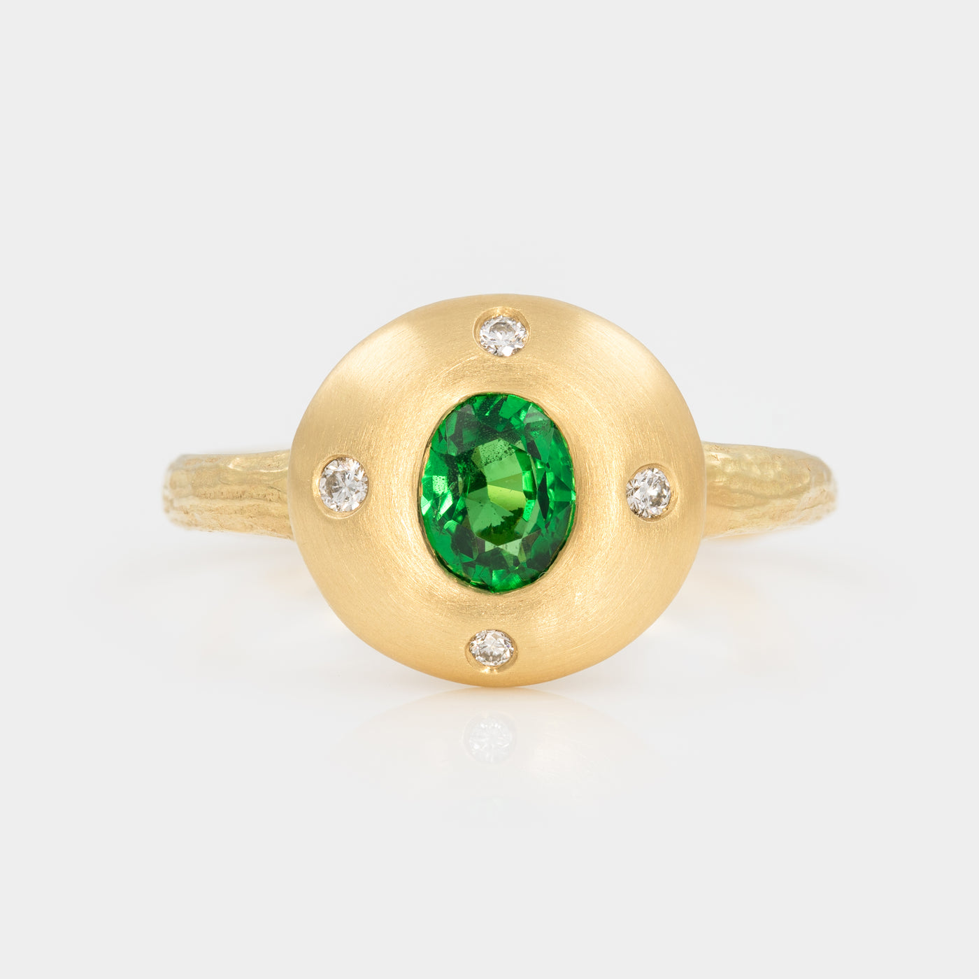 Gold ring with a green gemstone and small diamonds on a white background