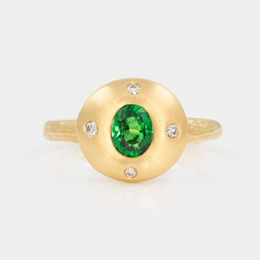 Gold ring with a green gemstone and small diamonds on a white background