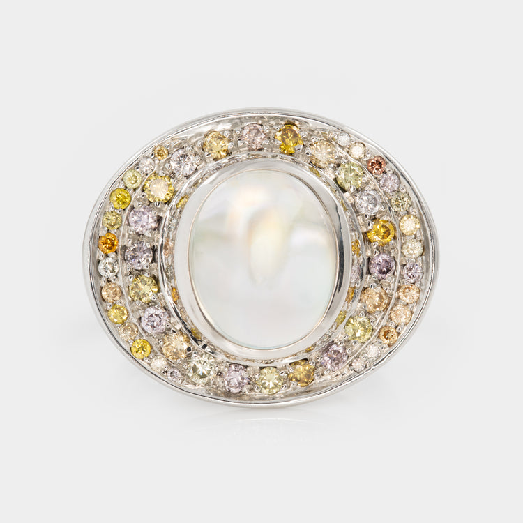 Front view of platinum ring with a central moonstone surrounded by multicolored diamonds on a white background