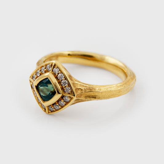 Gold ring with a green Alexandrite gemstone and diamond accents on a white background 3/4 view