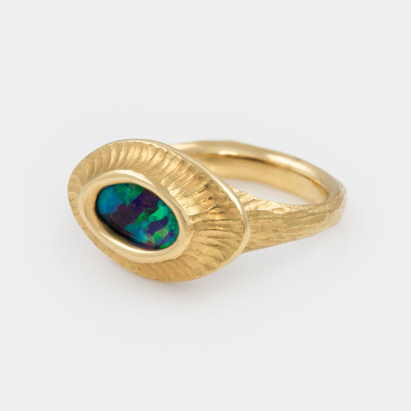 Gold ring with an opal stone on a white background