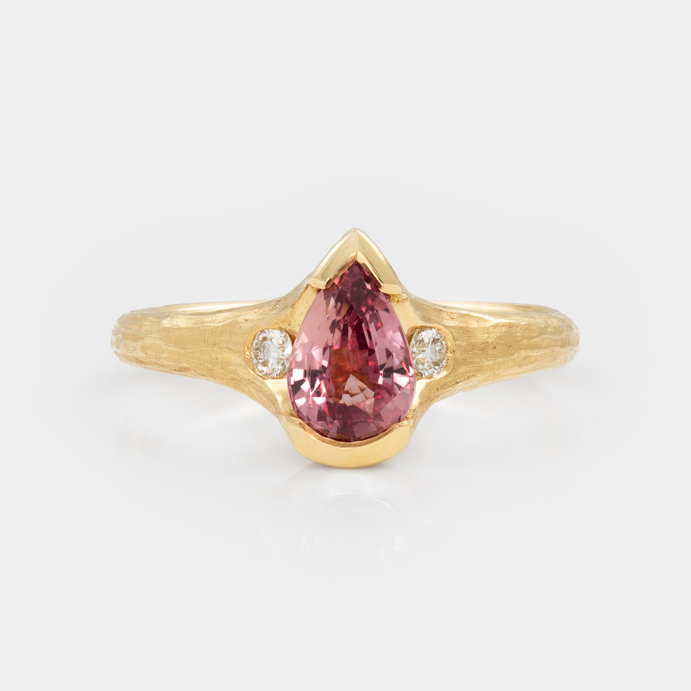 Gold ring with a pink gemstone and small diamonds on a white background