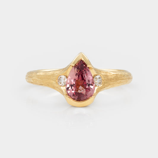 Gold ring with a pink gemstone and small diamonds on a white background