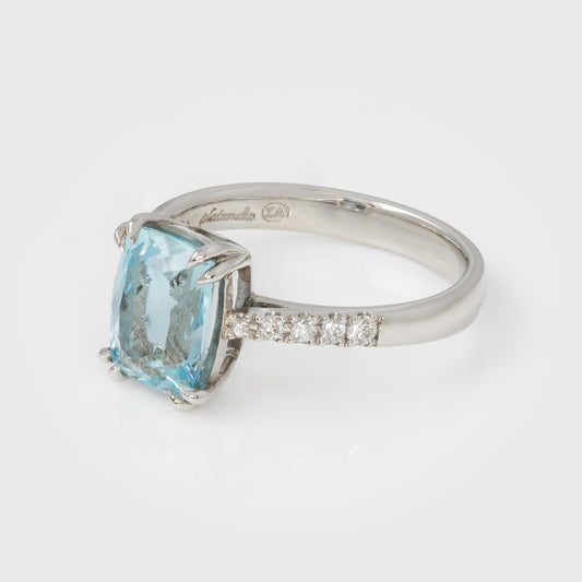 Silver ring with a large blue gemstone and smaller diamonds on a white background
