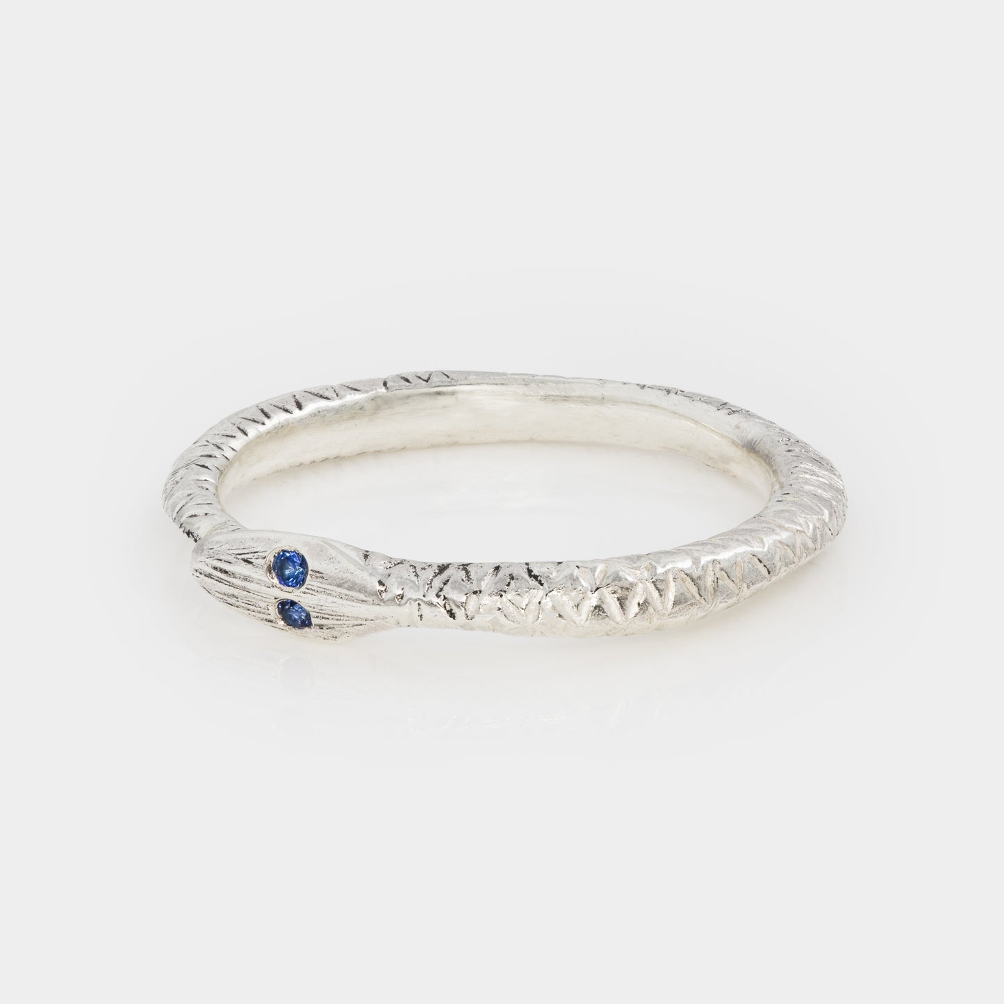Silver ring with a blue gemstone on a white background