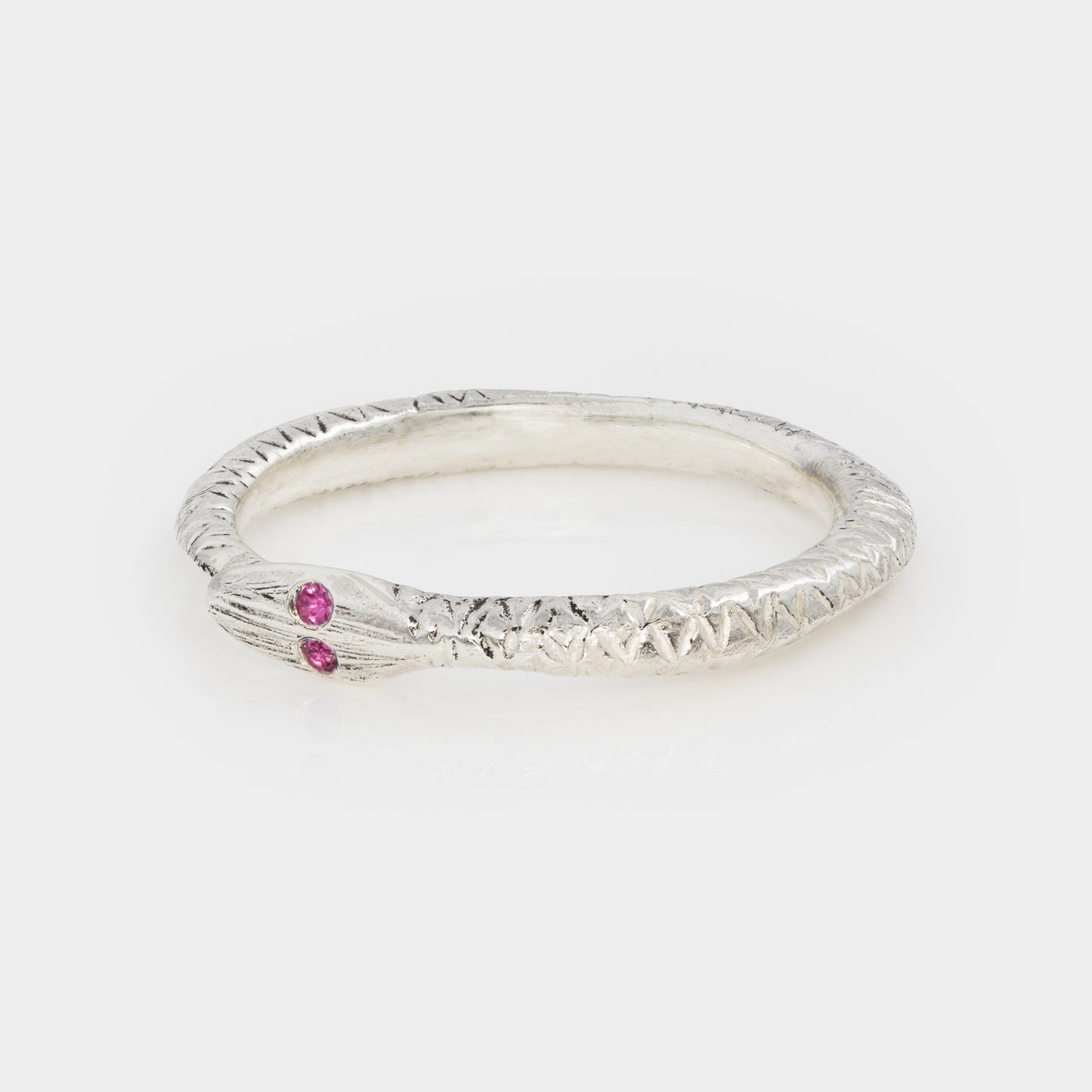 Silver ring with a pink gemstone on a white background